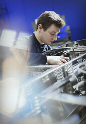 Worker inspecting machinery in steel factory - CAIF12615