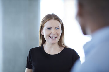 Smiling businesswoman talking to businessman - CAIF12630