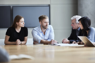 Business people discussing paperwork in meeting - CAIF12634