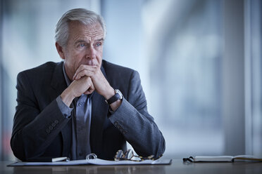 Pensive senior businessman looking away in conference room - CAIF12646