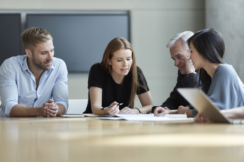 Business people reviewing paperwork in meeting stock photo