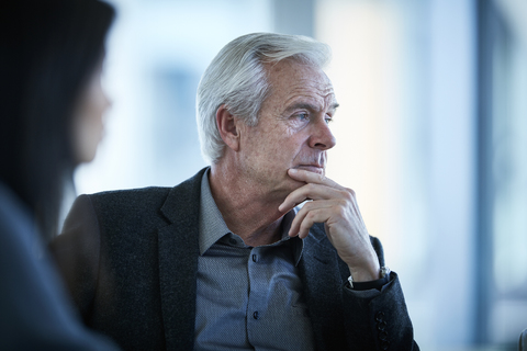 Serious senior businessman looking away stock photo