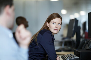 Businesswoman at computer listening to businessman - CAIF12669