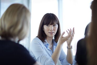 Businesswoman gesturing and talking in meeting - CAIF12670