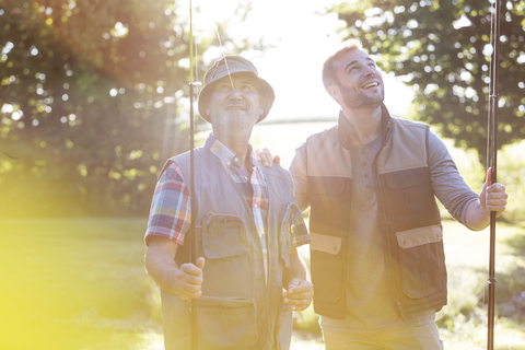 Vater und erwachsener Sohn mit Angelruten, lizenzfreies Stockfoto