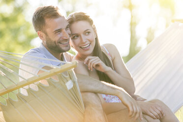 Affectionate young couple smiling in summer hammock - CAIF12685