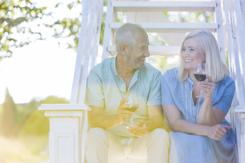 Älteres Paar trinkt Wein auf einer Sommertreppe, lizenzfreies Stockfoto