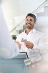 Worker giving customer change at cafe cash register - CAIF12769