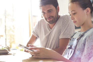 Vater und Tochter benutzen ein digitales Tablet - CAIF12781