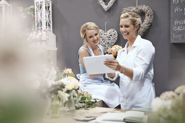 Lächelnde Floristen mit digitalem Tablet im Blumenladen - CAIF12789