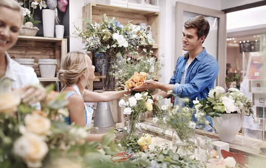 Florist gibt Mann Blumenstrauß im Blumenladen - CAIF12792