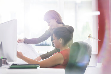 Architektinnen besprechen Baupläne am Schreibtisch und im Büro - CAIF12827