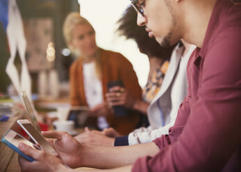 Man using digital tablet and cell phone in cafe - CAIF12843