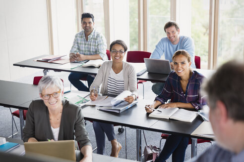 Lächelnde Schüler, die den Lehrer im Klassenzimmer der Erwachsenenbildung beobachten - CAIF12852