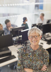 Porträt einer selbstbewussten älteren Frau in einem Computerunterrichtsraum der Erwachsenenbildung - CAIF12864