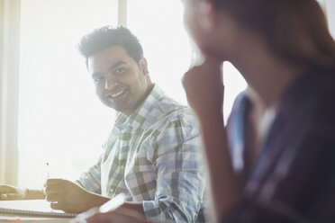 Smiling students talking in adult education classroom - CAIF12878