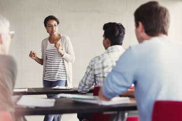 Lehrer spricht zu Schülern in einem Klassenzimmer der Erwachsenenbildung - CAIF12887