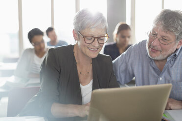 Schüler lernen am Laptop in einem Unterrichtsraum der Erwachsenenbildung - CAIF12924