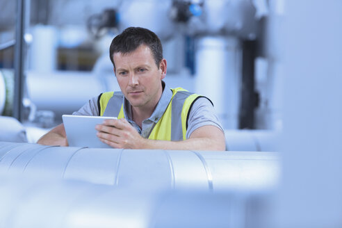 Arbeiter mit digitalem Tablet in einer Fabrik - CAIF12957