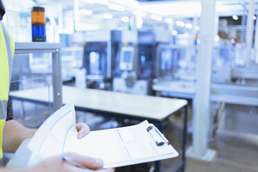 Close up worker with clipboard in factory - CAIF12972