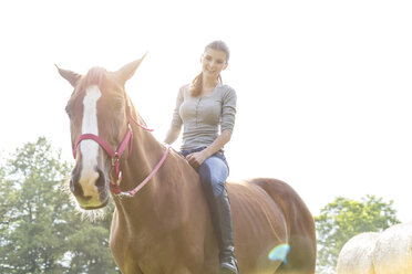 Lächelnde Frau reitet Pferd ohne Sattel - CAIF13013