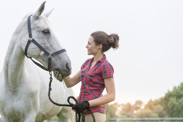 Woman feeding horse - CAIF13020