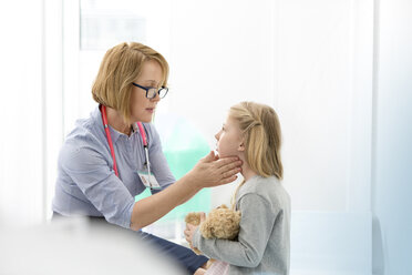 Kinderarzt kontrolliert die Drüsen eines Mädchens im Untersuchungsraum - CAIF13099