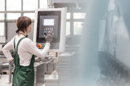 Arbeiter am Schaltpult bei der Bedienung von Maschinen in einer Fabrik - CAIF13107