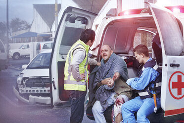 Rettungskräfte kümmern sich um das Unfallopfer im hinteren Teil des Krankenwagens - CAIF13130