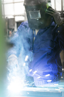 Schweißer in Arbeitsschutzkleidung bei der Arbeit in einer Fabrik - CAIF13147