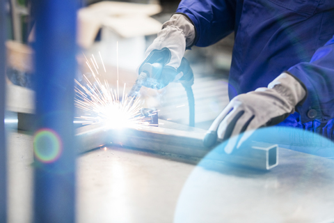 Schweißer schweißt Stahl in der Fabrik, lizenzfreies Stockfoto