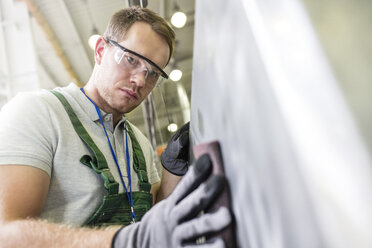 Konzentrierter Arbeiter beim Schleifen eines Teils in der Fabrik - CAIF13165