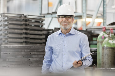 Portrait confident engineer with clipboard in factory - CAIF13195