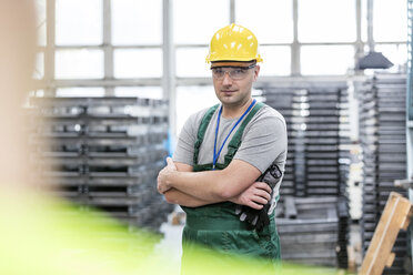 Portrait confident worker with arms crossed in factory - CAIF13198