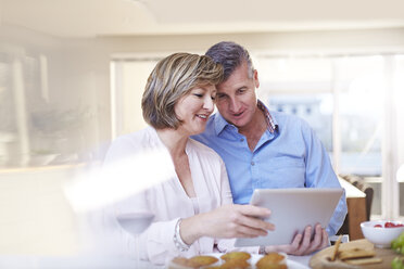 Couple using digital tablet in kitchen - CAIF13213