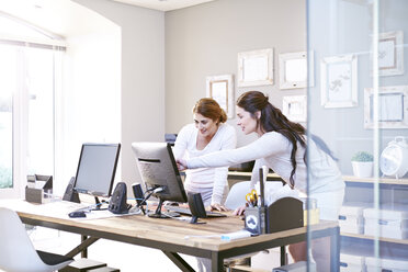 Geschäftsfrauen im Gespräch am Computer im Büro - CAIF13236