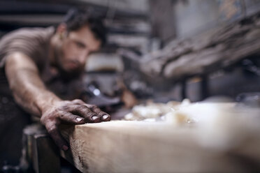 Craftsman chiseling wood in workshop - CAIF13244
