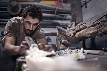 Craftsman chiseling wood in workshop - CAIF13247