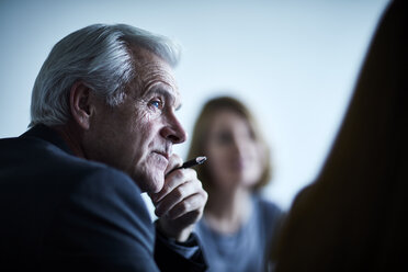 Attentive senior businessman listening in meeting - CAIF13270