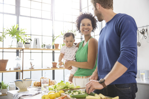 Glückliche Familie bei der Zubereitung einer Mahlzeit in der heimischen Küche, lizenzfreies Stockfoto