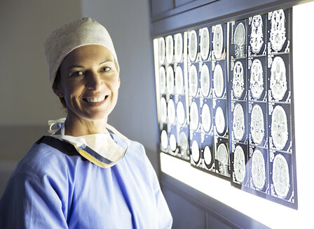 Portrait of smiling surgeon reviewing MRI scans - CAIF13319