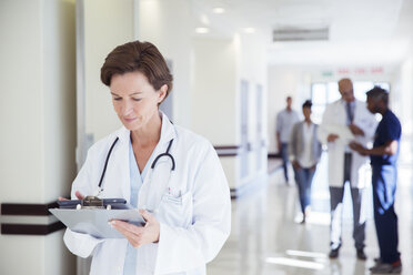 Arzt benutzt digitales Tablet im Krankenhausflur - CAIF13329