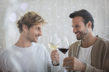 Lächelnde Männer, die mit Weingläsern anstoßen - CAIF13359