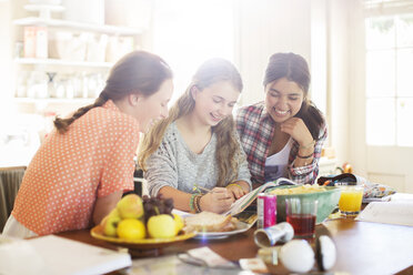 Drei Mädchen im Teenageralter lernen am Tisch im Esszimmer - CAIF13411