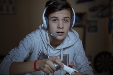 Teenage boy with headset playing video game - CAIF13426