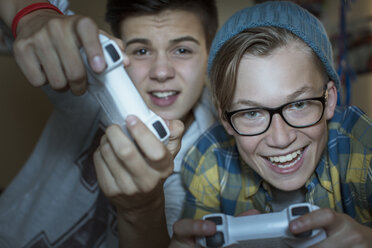 Zwei Jungen im Teenageralter spielen zusammen ein Videospiel - CAIF13444