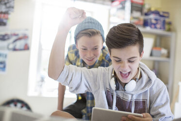 Zwei Jungen im Teenageralter haben Spaß bei der Nutzung eines digitalen Tablets - CAIF13447