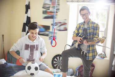 Zwei Teenager spielen Musik in einem Zimmer - CAIF13459