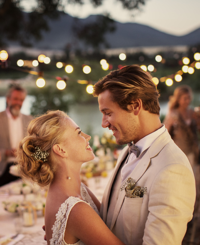 Porträt eines jungen Paares, das während eines Hochzeitsempfangs im Garten tanzt, lizenzfreies Stockfoto