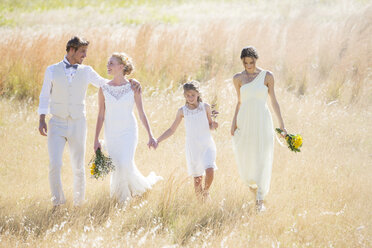 Junges Paar mit Brautjungfer und Mädchen auf einer Wiese - CAIF13538